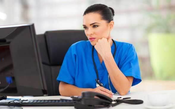A Nurse at a Desk that is Critical Thinking