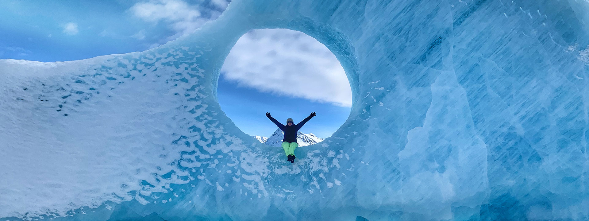 Woman celebrating on top of massive glacier