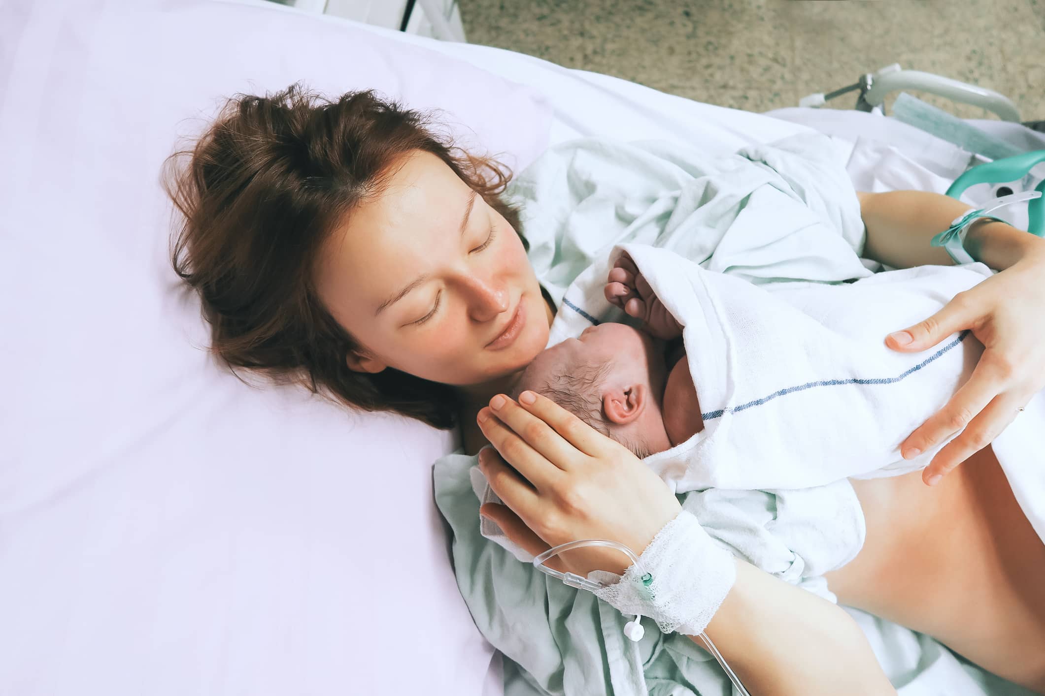 New mother embracing her newborn baby. New mother embracing her newborn baby.
