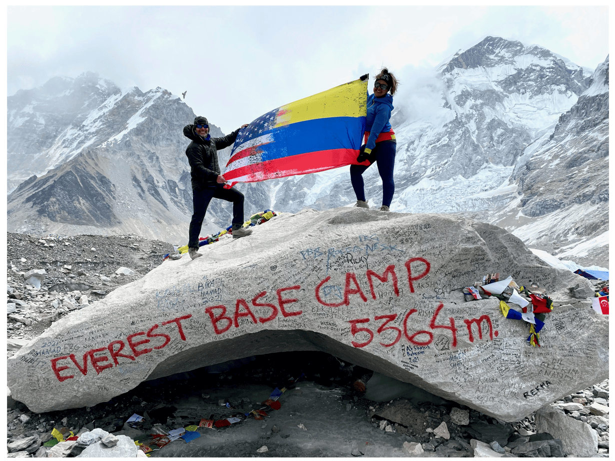 Travel nurse holding flag on top of Everest basecamp.