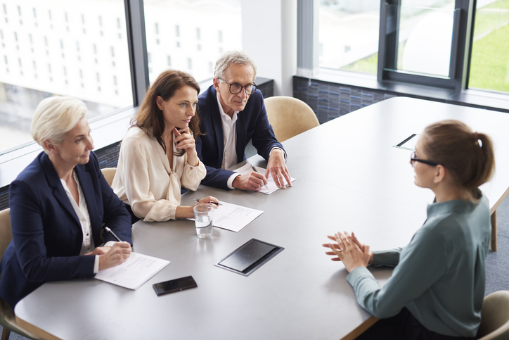 Travel nurse sitting in an interview with three healthcare professionals Travel nurse sitting in an interview with three healthcare professionals
