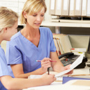 2 nurses working together on paperwork at nurses station 2 nurses working together on paperwork at nurses station