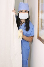 nurse with mask and surgical gloves peeking from behind hospital curtain nurse with mask and surgical gloves peeking from behind hospital curtain