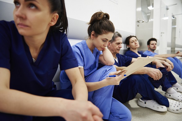 exhausted healthcare workers sitting on floor exhausted healthcare workers sitting on floor
