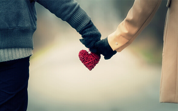 couple shot from behind holding hands and a heart couple shot from behind holding hands and a heart