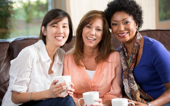 three female friends with heads leaning together three female friends with heads leaning together