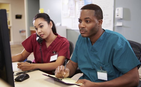 male and female nurse working at nurses' station male and female nurse working at nurses' station