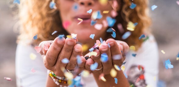 confetti blowing from woman's cupped hands confetti blowing from woman's cupped hands