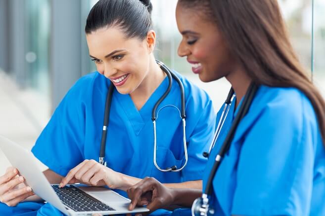 Two smiling nurses looking at computer Two smiling nurses looking at computer