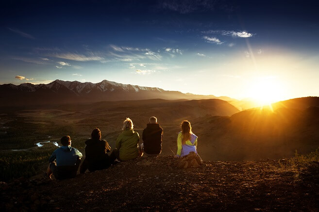 group of hikers in mountain watching sunrise or sunset group of hikers in mountain watching sunrise or sunset