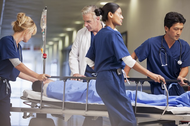 Healthcare workers transporting patient in bed Healthcare workers transporting patient in bed