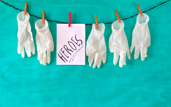 white surgical gloves hanging on a line with note that says heroes white surgical gloves hanging on a line with note that says heroes