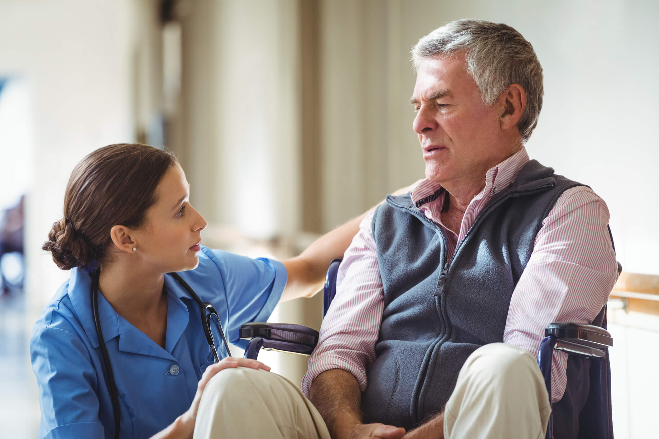 kneeling nurse talking to senior patient in wheelchair kneeling nurse talking to senior patient in wheelchair