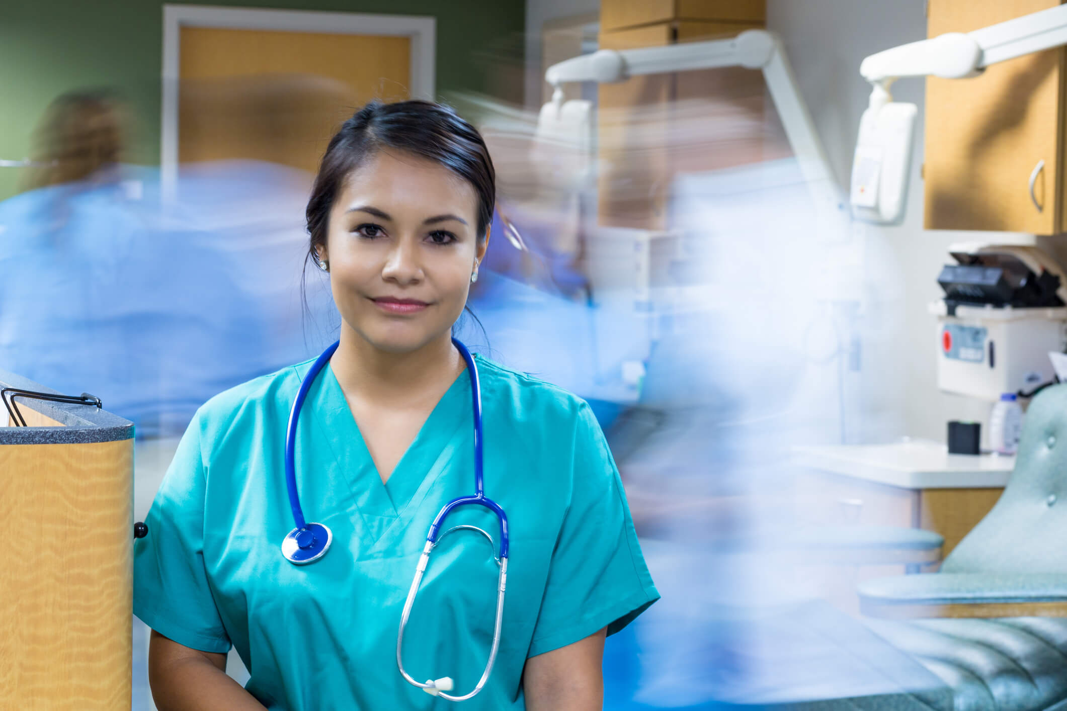 nurse looking at camera with blurred figures behind nurse looking at camera with blurred figures behind