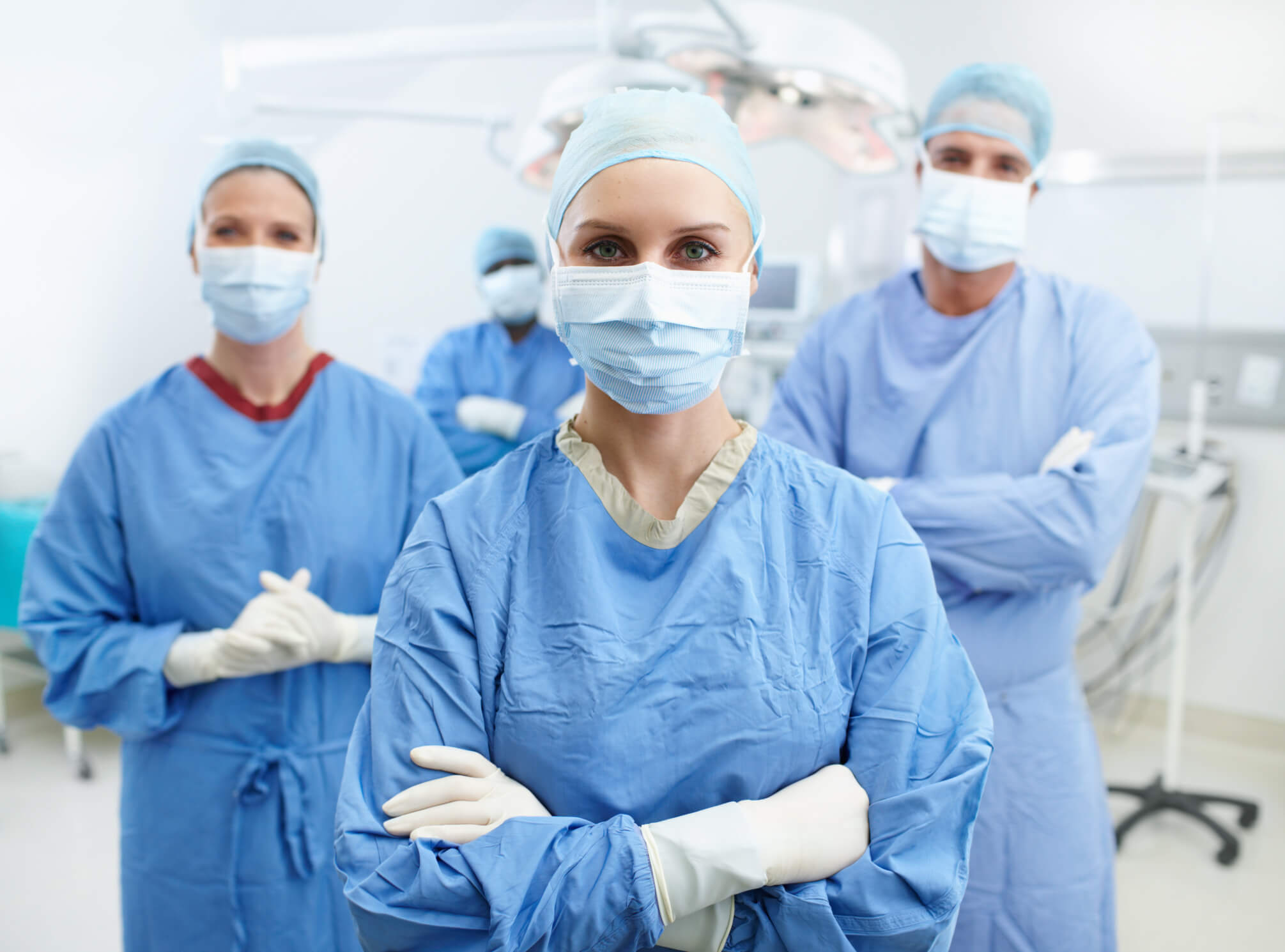 group of healthcare professionals in protective gear standing with arms crossed group of healthcare professionals in protective gear standing with arms crossed