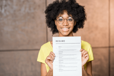 smiling young woman showing a paper resume smiling young woman showing a paper resume
