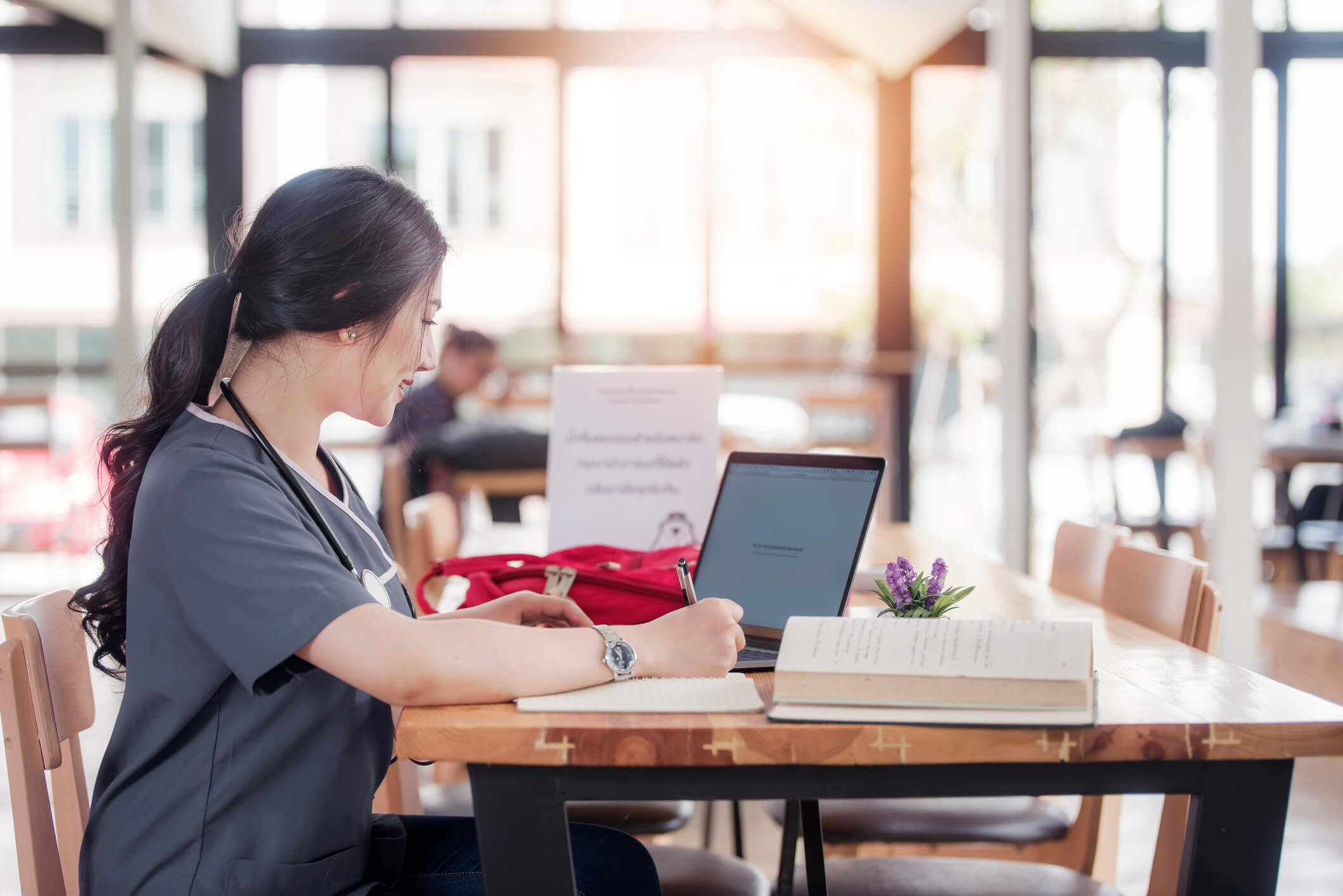 Nurse in computer lab or library working on laptop Nurse in computer lab or library working on laptop