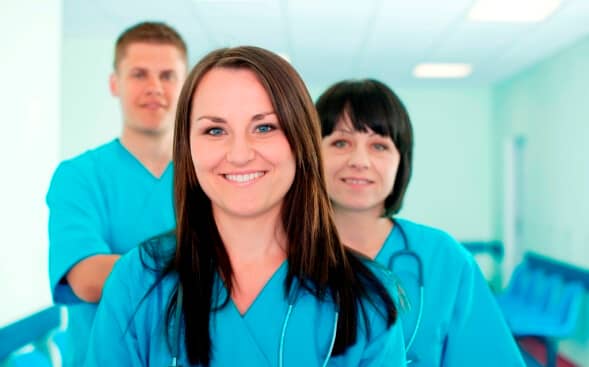 3 nurses in a row standing confidently together 3 nurses in a row standing confidently together
