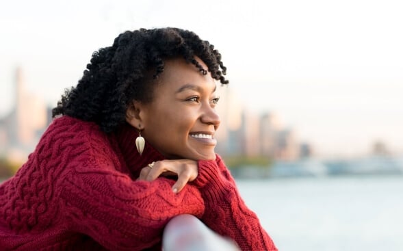 woman looking out over water with smiling positive look woman looking out over water with smiling positive look