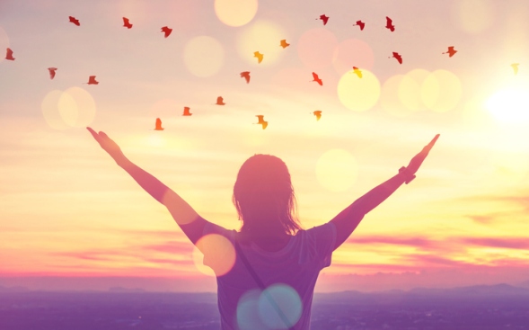 woman with arms up facing the sun with birds flying above woman with arms up facing the sun with birds flying above