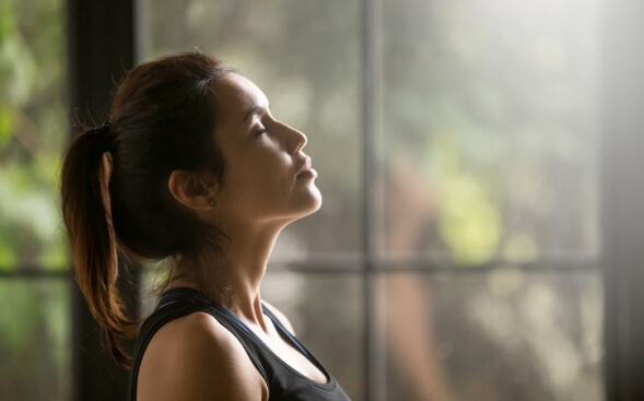 relaxed woman in front of windows and streaming sun relaxed woman in front of windows and streaming sun
