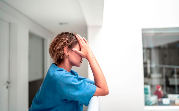 sad nurse with head in hands sad nurse with head in hands