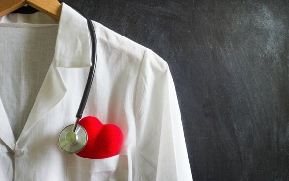 Medical coat on hanger with stethoscope and heart in chest pocket Medical coat on hanger with stethoscope and heart in chest pocket