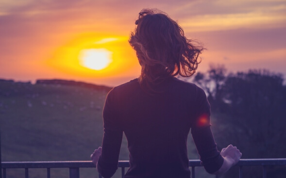 woman outside watching sunset woman outside watching sunset
