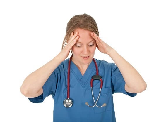 Stressed Nurse with hands on face Stressed Nurse with hands on face
