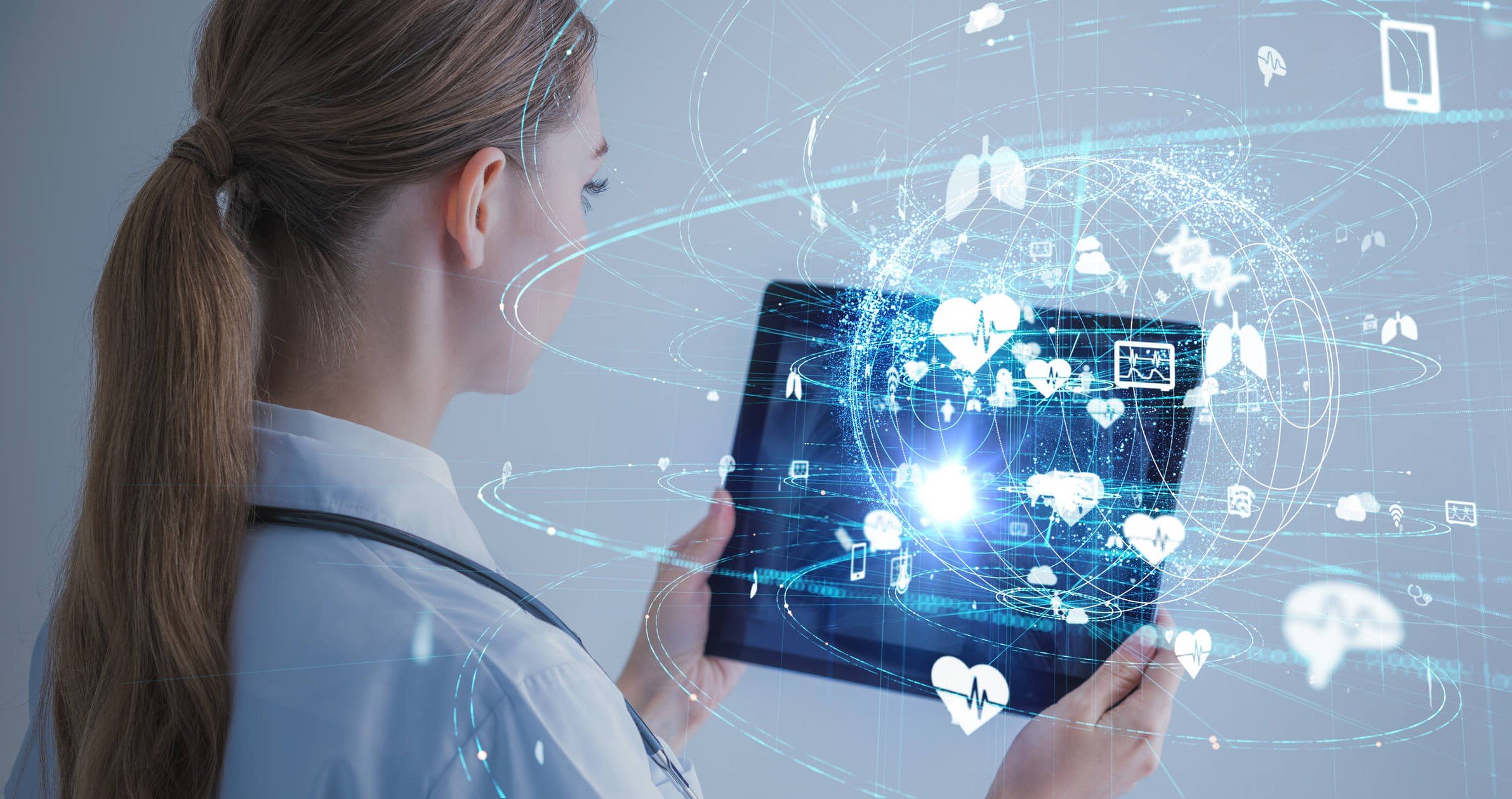 healthcare professional holding tablet with electronic futuristic symbols emitting from it healthcare professional holding tablet with electronic futuristic symbols emitting from it