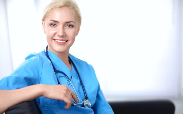 nurse turned with her arm on chair back smiling at camera nurse turned with her arm on chair back smiling at camera