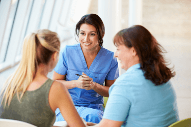 Smiling nurse talking to mother and teen Smiling nurse talking to mother and teen