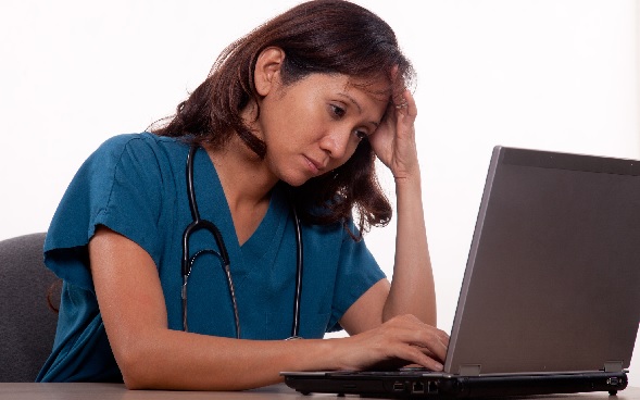 Sad, tired nurses looking at computer Sad, tired nurses looking at computer