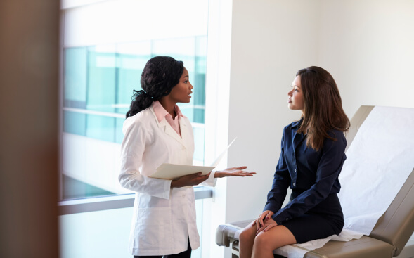 healthcare professional talking to patient in business attire in healthcare office healthcare professional talking to patient in business attire in healthcare office