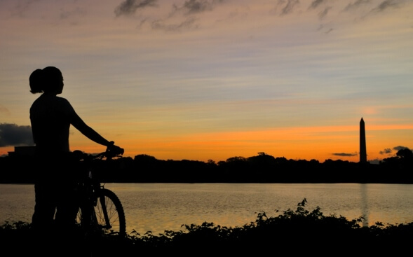 Washington's Potomac River with woman on bike in shadow Washington's Potomac River with woman on bike in shadow