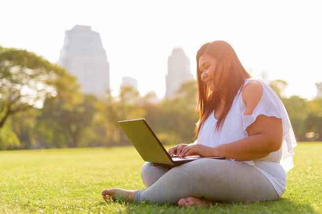 woman sitting outside using laptop woman sitting outside using laptop