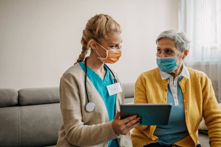 Nursing showing patient information on a mobile device Nursing showing patient information on a mobile device