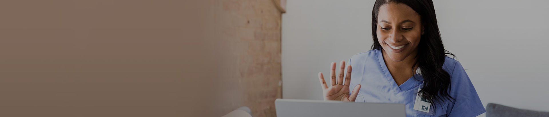 Nurse waving in front of laptop